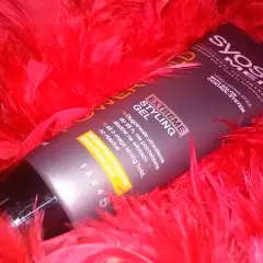 Syoss Men Extreme Styling Gel, dla mega mocnego utrwalenia włosów na żel, otoczony czerwonymi piórami.