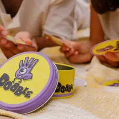 Gra w Dobble to szybkie szukanie wspólnych symboli na kartach. Dzieci i dorośli świetnie się bawią, ucząc się, jak się gra w Dobble.