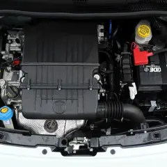 Silniki Fiata 500 w komorze silnika. Widoczny czarny plastikowy element z logo FIAT, akumulator i płyny eksploatacyjne.