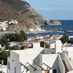 Vista de la bahía de San José, con sus casas blancas y el puerto deportivo. El paisaje de **4 nudos cabo de gata** se extiende hasta el mar azul.