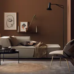 Gemütliches Wohnzimmer in warmem Braunton mit Sofa, Sessel und Kunst.