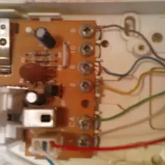 Wnętrze unifonu z widoczną płytką drukowaną, elementami elektronicznymi i przewodami.