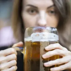 Kobieta pije piwo z dużego kufla. Zastanawiasz się, ile kalorii ma piwo smakowe?