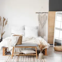 Białe lustro stojące odbija okno, dodając lekkości sypialni w stylu boho.