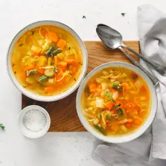 Dwie miseczki aromatycznej zupy mocy, pełnej warzyw i makaronu, gotowe do podania.