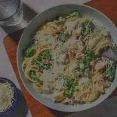 Ein Teller Spaghetti Carbonara, original italienisch, mit Brokkoli und Speck, bestreut mit Parmesan.