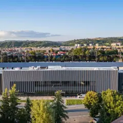 Nowoczesny stadion Sandecji w Nowym Sączu, otoczony zielenią i górami, gotowy na nowe emocje.