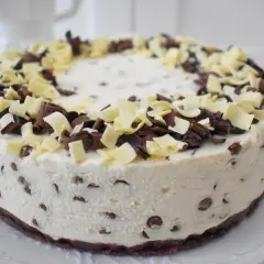 Pyszny tort straciatella z kawałkami czekolady i wiórkami białej czekolady na wierzchu.