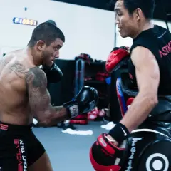 Fighter throws an uppercut punch during a training session in a gym.