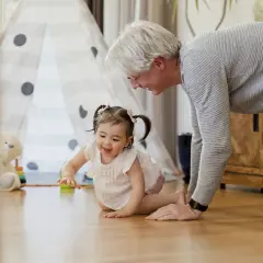 Nonno incoraggia la nipotina a gattonare, un momento prezioso per capire a quanti mesi si gattona.