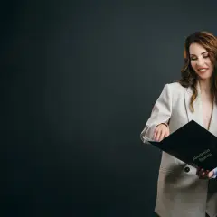 Dwie kobiety przeglądają folder "Akademia Śpiewu".