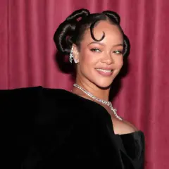 Rihanna lächelt in die Kamera, ihr Haar ist zu zwei eleganten Knoten hochgesteckt. Man fragt sich, ob sie bald ein neues Lied veröffentlicht.