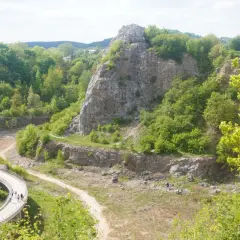 Malowniczy krajobraz kamieniołomu w rezerwacie przyrody Kielce. Ścieżka dla pieszych wije się wśród zieleni i skalnych formacji.
