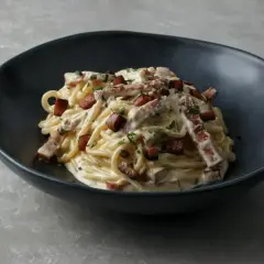 Pyszna carbonara w czarnej misce, idealna inspiracja, jak zrobić carbonare.