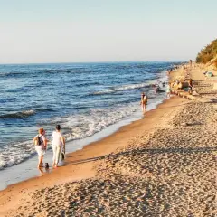 Spacer po plaży, idealne miejsce, gdzie jechać nad morze w listopadzie. Spokojne fale, piaszczysty brzeg i łagodne słońce.