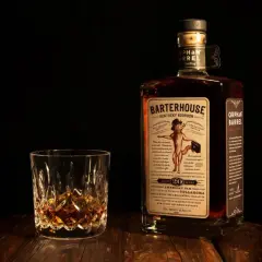 Verre de bourbon ambré et bouteille Orphan Barrel Barterhouse 20 ans. Une dégustation pour apprécier la différence whiskey bourbon.