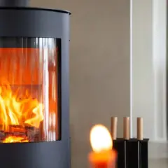 Moderner Kaminofen mit sichtbarem Feuer, erfüllt BIMSCHV Stufe 2. Gemütliches Ambiente im Wohnraum.