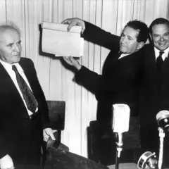 David Ben-Gurion hält ein Dokument hoch, das die Entstehung Israels symbolisiert.
