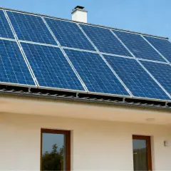 Panele fotowoltaiczne na dachu białego domu. Czy fotowoltaika się opłaca? Słońce świeci, produkując czystą energię.