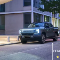 Elegancka para idzie obok nowoczesnego, elektrycznego pickupa Maxus eTerron9. Auto zdobyło 5 gwiazdek w testach Euro NCAP.