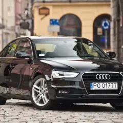 Błyszczący czarny Audi A4 b8 na brukowanej ulicy.