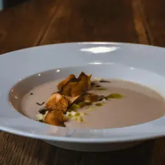 Krämig soppa med krispiga chips och olivolja, serverad på Radisson Blu Helsingborg restaurang.