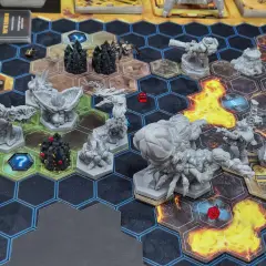 Das **Deep Rock Galactic Brettspiel** zeigt eine spannende Szene mit Zwergen-Miniaturen, Monstern und Würfeln auf einem hexagonalen Spielfeld.