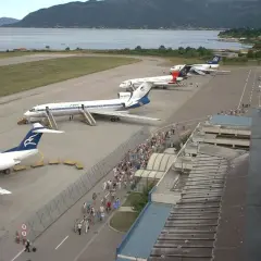 Samoloty na płycie lotniska w Budvie, pasażerowie idący do terminalu.