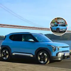 El ev2 Kia azul, con un diseño moderno, cruza un puente icónico. En un círculo, se ve su parte trasera con grafitis.