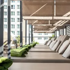 Tumbonas listas para el relax en la terraza del Meliá Valencia, con toallas verdes y vistas a la ciudad.