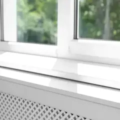 Biały parapet zewnętrzny z widocznym uszczelnieniem, chroniący przed warunkami atmosferycznymi.