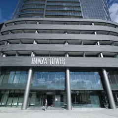 Nowoczesny budynek Hanza Tower z przeszklonym parterem i tarasami.