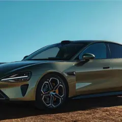La nuova Xiaomi SU7, un'auto elettrica dal design audace, si presenta in un paesaggio desertico sotto un cielo azzurro.