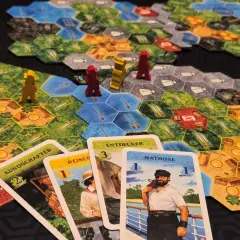 Spielbrett mit Figuren und Karten. Ein Seemann, Entdecker und andere Charaktere sind auf den Karten abgebildet. Ein spannendes Spiel für alle, die gute Brettspiele lieben.