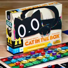 Gra planszowa "Cat in the Box" z czarnym kotem na pudełku i kolorowymi znacznikami na planszy.
