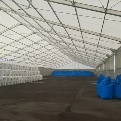 Wewnątrz namiotu bez zgłoszenia, stosy białych worków z nawozem Yara i rzędy niebieskich big-bagów czekają na transport.