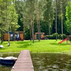 Domek nad jeziorem, łódka przy pomoście, plac zabaw i las – to piękne walory turystyczne Polski.