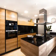 Cucina moderna con ante in legno di rovere, piano in quarzo nero e isola centrale. Un progetto per rinnovare cucina in legno con stile.