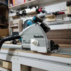 Sega circolare Makita su binario, pronta per tagliare profilo alluminio con precisione. Aspirazione collegata per un ambiente di lavoro pulito.
