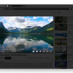 Widok na spokojne jezioro i góry, odbijające się w wodzie. W tle widać chmury. Interfejs YouTube z filmem i sugerowanymi treściami, wszystko w stylu motywy chrome.