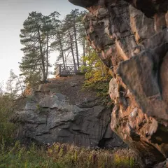 Kamienne miasto z platformą widokową wśród sosen. Skały tworzą naturalne miasto, a drewniana konstrukcja zaprasza do podziwiania krajobrazu.