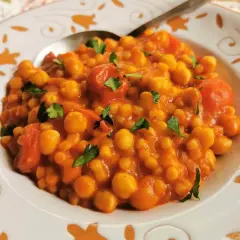 Piatto di ceci e pomodoro, guarnito con prezzemolo. Un sapore che ricorda la peretta formaggio, un classico.