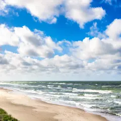 Plaża nad Bałtykiem, falujące morze i błękitne niebo z chmurami. Trudno oszacować, ile wody jest w Bałtyku, ale jest jej mnóstwo!