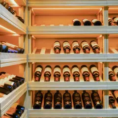 Étagères en bois remplies de bouteilles de vin, parfait pour faire sa cave à vin.