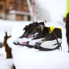 Buty narciarskie w śniegu. Zastanawiasz się, jak prać buty narciarskie? Oto one, gotowe do czyszczenia po dniu na stoku.