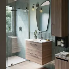 Salle de bain moderne avec douche vitrée, meuble vasque en bois, miroir asymétrique et carrelage vert d'eau. La taille moyenne d'une salle de bain est bien représentée.