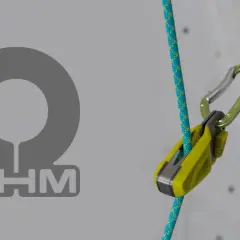 Ohm wspinaczka: przyrząd asekuracyjny Edelrid z liną na tle ściany wspinaczkowej.