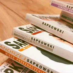 Stos książek Andrzeja Sapkowskiego, idealny przewodnik, jak czytać Wiedźmina od początku: Miecz Przeznaczenia, Krew Elfów, Czas Pogardy.