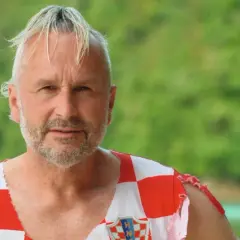 Fabian Turkalj, en man med grått hår och skägg, bär en sliten tröja med Kroatiens flagga.