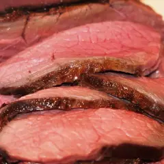 Tranches de rosbeef juteuses, parfaitement saisies, révélant une cuisson rosée idéale. Un délice pour les amateurs de viande.